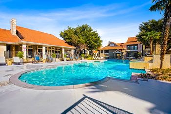 A swimming pool in front of a house with a resort style pool